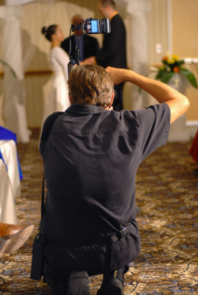 Wedding photographer in action, taking a picture of the bride and groom
